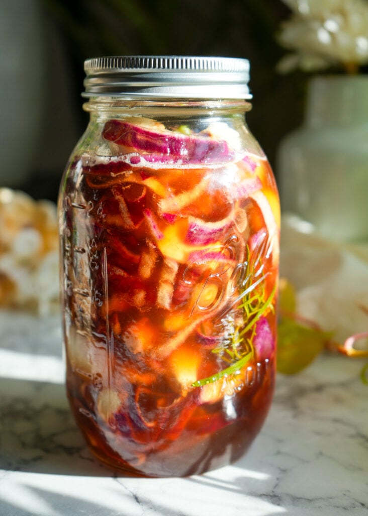 day two of fermenting 36 ounce mason jar filled with rosemary onion garlic cinnamon and honey to make honey cough syrup