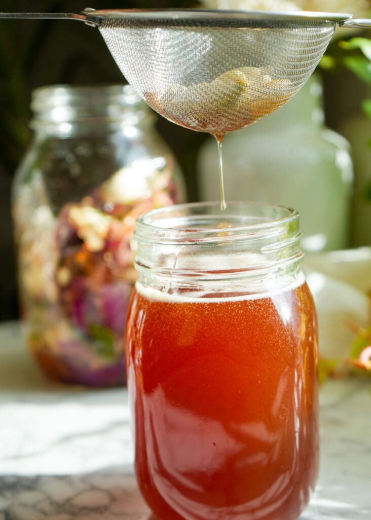 straining honey to make cough syrup