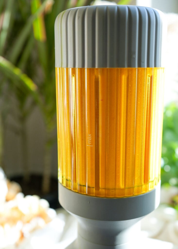 A blender filled with lemon turmeric frozen tea bomb mixture.