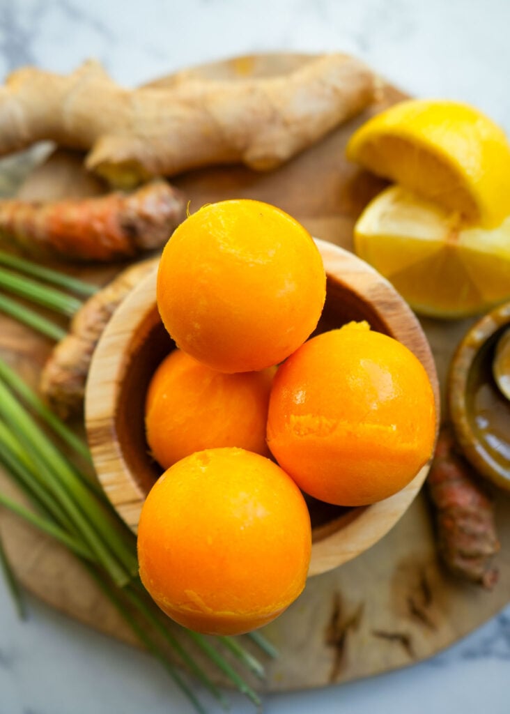 a bowl of frozen tea bombs surrounded by fresh ingredients