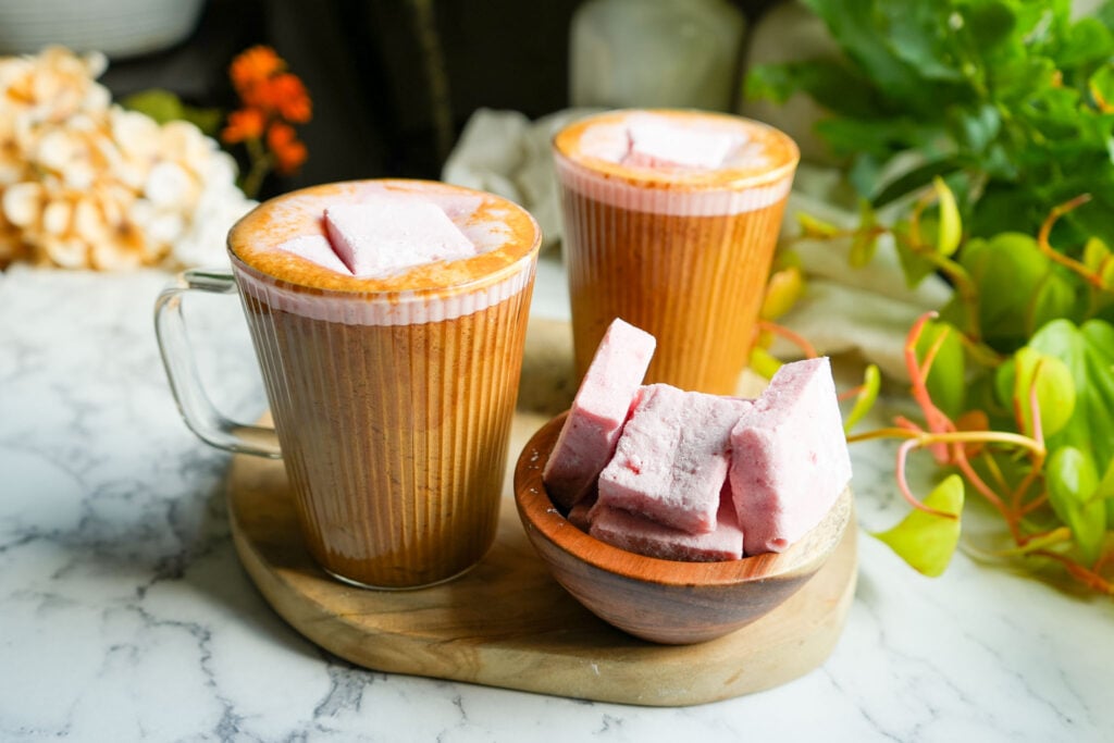 two glass mugs filled with bone broth hot chocolate and topped with homemade marshmallows