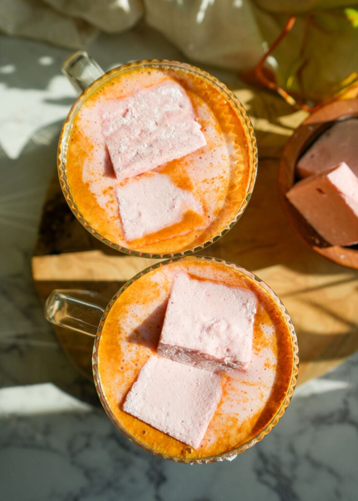 two glass mugs filled with bone broth hot chocolate and topped with homemade marshmallows