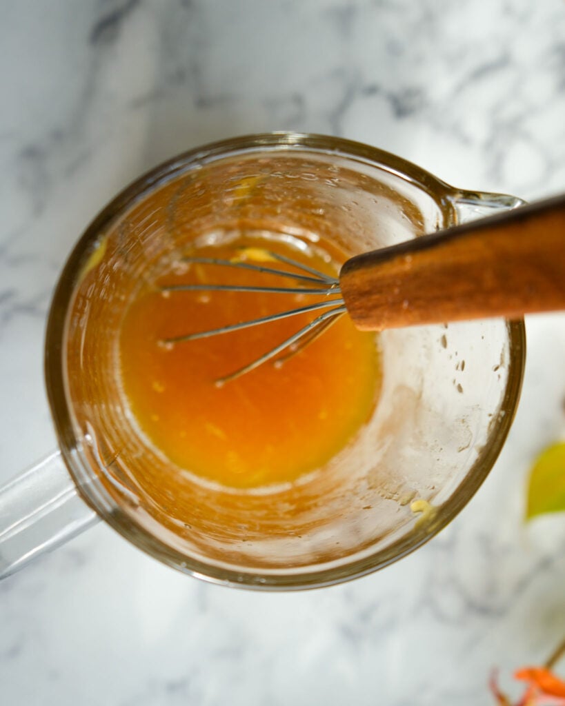 a measuring cup with honey and lime mixed