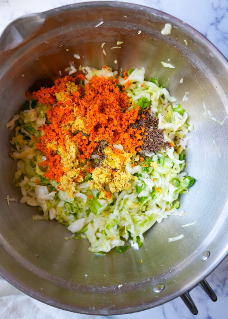 ingredients for gut healthy sauerkraut added in a large bowl