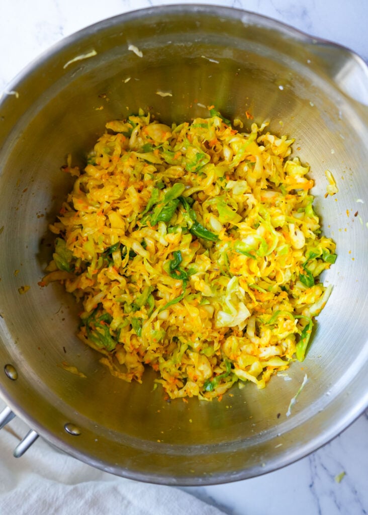 ingredients for gut healthy sauerkraut added in a large bowl combined before adding too a jar for fermenting