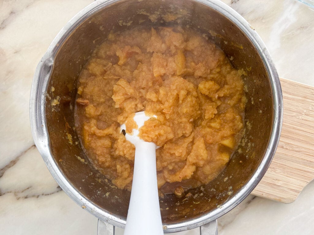 homemade apples sauce in a pot with an immersion blender